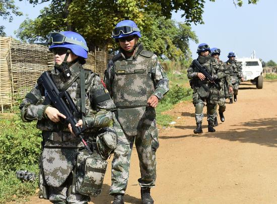 Zhang Yuanyuan, a member of China's first female infantry squad to serve in the UN peacekeeping mission, patrols an area in South Sudan with her male colleagues in 2015. (Photo/CHINA DAILY)