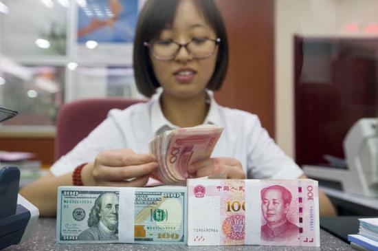 An employee counts money at a bank in Taiyuan, capital of Shanxi Province. (Photo/China News Service)