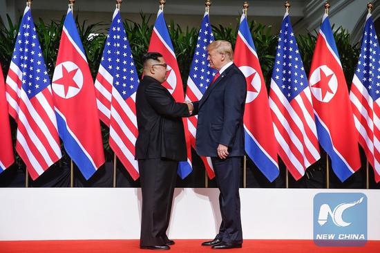 In this file photo, top leader of the Democratic People's Republic of Korea (DPRK) Kim Jong Un (L) shakes hands with U.S. President Donald Trump in Singapore before the first-ever DPRK-U.S. summit, on June 12, 2018. (Xinhua/The Straits Times)
