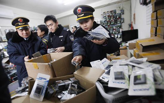 Law enforcement officers find a large number of counterfeit mobile phone batteries from a Taobao retailer hidden in a residential community in Shanghai. (Photo provided to China Daily)