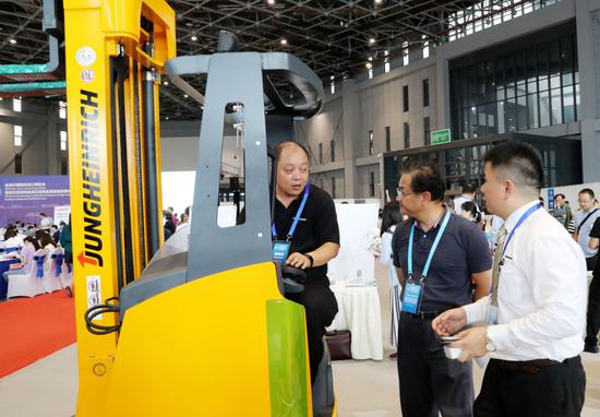 A Jungheinrich employee addresses queries from visitors at the pre-expo event of the CIIE in Shanghai. (Photo/Xinhua)