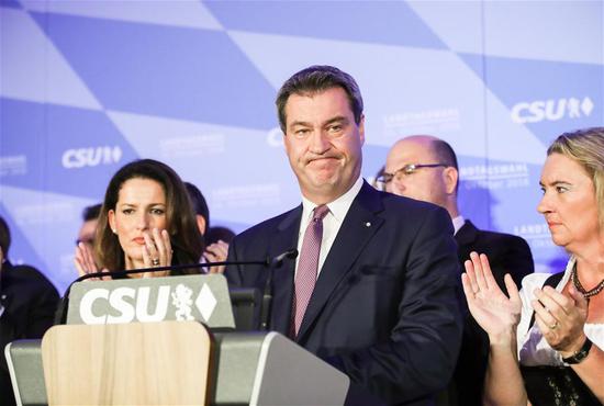 German Christian Social Union's candidate and Bavarian governor Markus Soeder (C) reacts as he delivers a speech after the initial forecast at the Maximilianeum in Munich, Germany, on Oct. 14, 2018. The Christian Social Union (CSU), one of the three ruling parties in Germany, suffered great loss Sunday in the state election in Bavaria, according to the initial forecast by the public broadcasters ARD and ZDF. (Xinhua/Shan Yuqi)