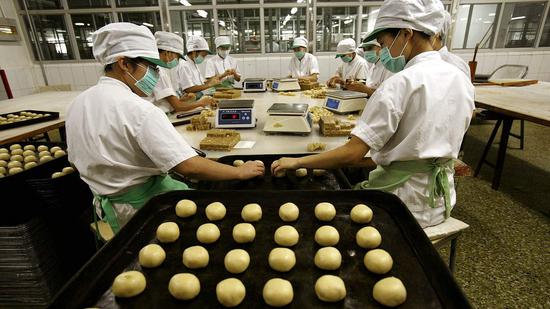 Workers preparing mooncakes at a Beijing Daoxiangcun Foodstuff Co., Ltd's factory.