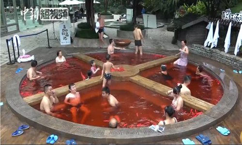 Bathers enjoy a hotpot-shaped pool containing water treated with medicinal herbs at a hot springs in Chongqing. (Source: China News Service)