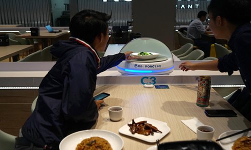 Customers pick their orders from a robot in Robot.HE in Shanghai. (Photo: Yang Hui/GT)


