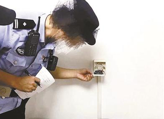 A policewoman checks a socket of a Ziroom apartment.  (Photo/Beijing Youth Daily)