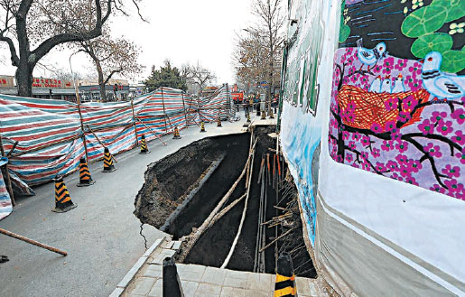 This photo taken on Jan 24, 2015 shows a big hole on a street in Beijing's Xicheng district. The hole has since been filled in with 1,400 cubic meters of concrete. (Photo by Xu Xiaofan / for China Daily)