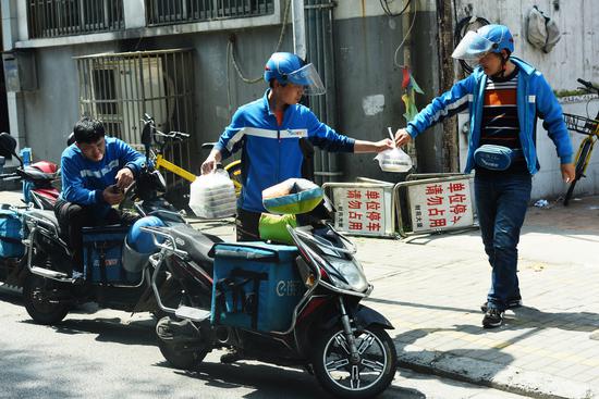 Employees of Ele.me handle a customer's order in Hangzhou, Zhejiang Province.  (Photo by Long Wei / for China Daily)