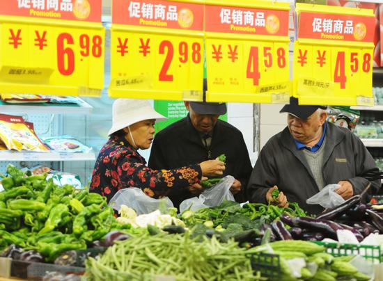 Shoppers select vegetables at a supermarket in Jiujiang, Jiangxi Province. (Photo by Hu Guolin/For China Daily)