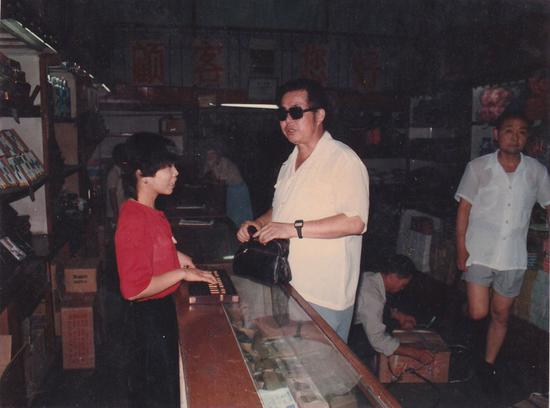 Zheng Juxuan buys small commodities at a shop on Hanzheng Street in the 1990s. (Photo/China Daily)