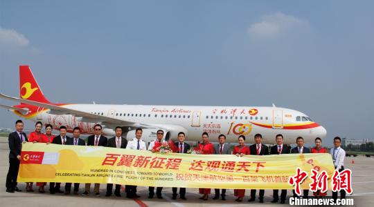 Staff members of Tianjin Airlines pose before a plane. (File photo/China News Service)