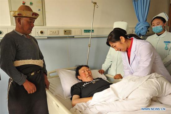 Doctor Yuan Xiaolan (R, front) from Guangdong examines a patient at the People's Hospital in Nyingchi, Southwest China's Tibet autonomous region, Aug. 16, 2018. (Photo/Xinhua)