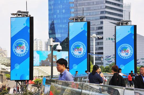People walk past signs for the China International Import Expo in Shanghai's Lujiazui area. (Photo provided to China Daily)