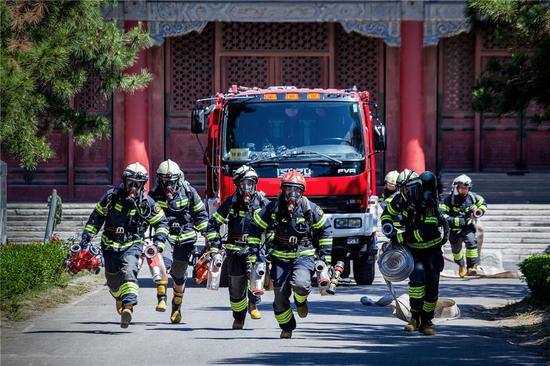 Drills are staged frequently at the Palace Museum in Beijing, where a team is stationed by the east gate to keep watch for fire in turn 24 hours a day. (Photo/China Daily)