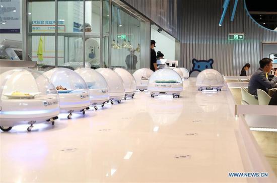 AGV (automated guided vehicle) robots line up to serve food to customers in a smart restaurant operated by Chinese e-commerce giant Alibaba at the National Exhibition and Convention Center in east China's Shanghai, Oct. 15, 2018. (Xinhua/Fang Zhe)