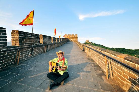Mark Levine, a teacher at Minzu University of China, plays his guitar on the Great Wall in 2011. (Photo provided to China Daily)
