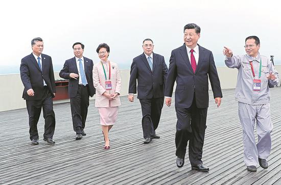 President Xi Jinping, accompanied by leading officials of Hong Kong, Macao and Guangdong province, tours the Hong Kong-Zhuhai-Macao Bridge in Zhuhai, Guangdong province, after attending its opening ceremony on Tuesday. (Photo provided to China Daily)