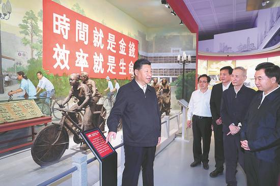 President Xi Jinping, also general secretary of the Communist Party of China Central Committee, visits an exhibition in Shenzhen about the 40th anniversary of reform and opening-up in Guangdong province on Wednesday. The banner says, “Time is money, efficiency is life”. (Photo/Xinhua)