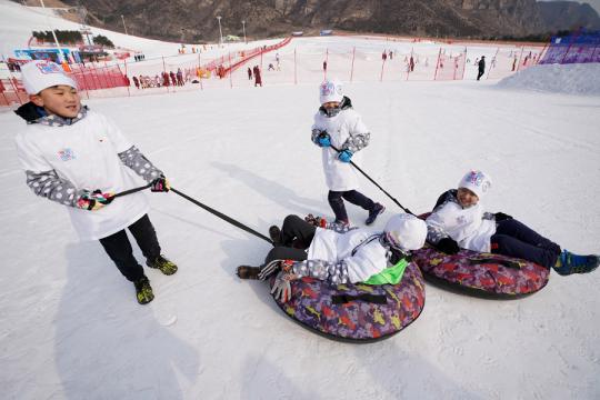 Children play at the Shijinglong Ski Resort in Yanqing, Beijing, on Jan 21. (Photo/Xinhua)
