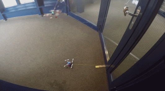 Outfitted with advanced gripping technologies and the ability to move and pull on objects around it, FlyCroTugs can jointly lasso the door handle and heave the door open. (Gif via Stanford University)