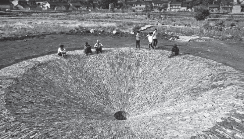 Artist Hu Quanchun's work, a 12-meter diameter stone drain in a rice field, records the history of Yubulu, a picturesque village in Guizhou province.(Photo provided to China Daily)