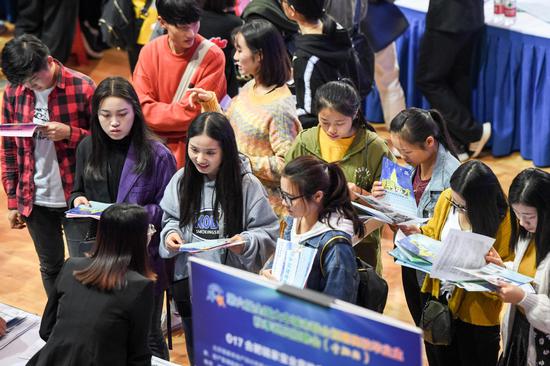 Job seekers speak with recruiters at Hefei University in Hefei, Anhui province, at a job fair for college graduates. (Photo/Xinhua)