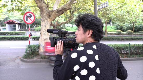 Takeuchi shooting on his camera in Nanjing City, eastern China's Jiangsu Province. /CGTN Photo