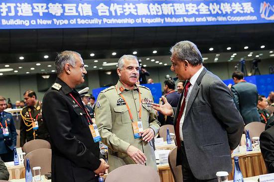 Participants in the Eighth Beijing Xiangshan Forum have a conversation on Thursday in Beijing. The three-day forum, which ends on Friday, aims to strengthen regional security dialogues and to enhance international peace and development. (Photo by Wang Zhuangfei/China Daily)
