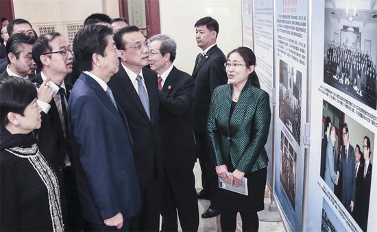 Premier Li Keqiang and Japanese Prime Minister Shinzo Abe tour an exhibition about bilateral economic and trade cooperation progress in Beijing on Thursday. (XU JINGXING / CHINA DAILY)