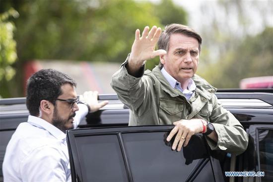Presidential candidate Jair Bolsonaro waves to his supporters as he leaves a polling station in Rio de Janeiro, Brazil, on Oct. 28, 2018. Right-wing candidate Jair Bolsonaro won Brazil's presidential run-off on Sunday. (Xinhua/Li Ming)