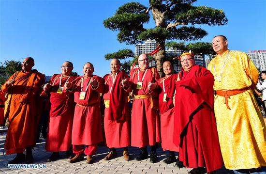 Guests for the fifth World Buddhist Forum pose for group photos during a tree planting activity in Putian, southeast China's Fujian Province, Oct. 28, 2018. A record number of over 1,000 Buddhists, scholars and representatives from 55 countries and regions attended the fifth World Buddhist Forum, which will last until Oct. 30.(Xinhua/Wei Peiquan)