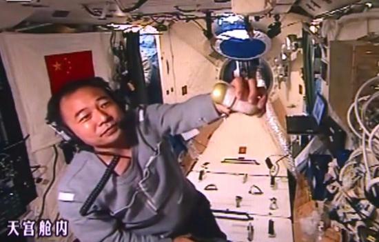 Jing Haipeng conducts an experiment on board Tiangong II on breeding silkworms in space. (Photo/Xinhua)