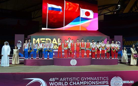 Team China (C), Team Russia (L) and Team Japan pose on the podium after the Men's Team Final at the 2018 FIG Artistic Gymnastics Championships in Doha, capital of Qatar, Oct. 29, 2018. Team China won the gold medal. (Xinhua/Nikku)