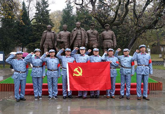 Wearing uniforms of the Eighth Route Army, tourists pose for photos at a red tourism site in Yan'an, Shaanxi Province. (Huo Yan/China Daily)