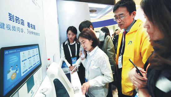 Visitors experience interactive medical service provided by Wuzhen Internet Hospital at an intelligent drugstore in Hangzhou, Zhejiang Province. (Photo by Long Wei/For China Daily)