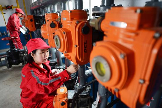 PetroChina employees conduct daily inspections on equipment at a facility in Puyang, Henan Province. (Photo by Tong Jiang/For China Daily])