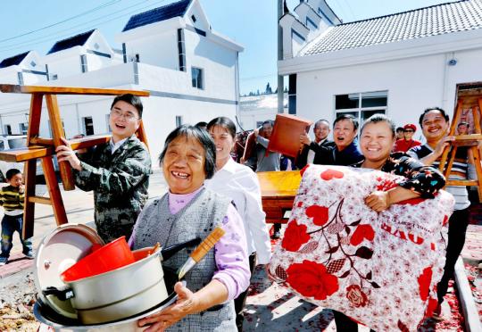 Farmers in Poyang county, Jiangxi Province, move from shanty houses into new villas on Sunday. (ZHUO ZHONGWEI/FOR CHINA DAILY)