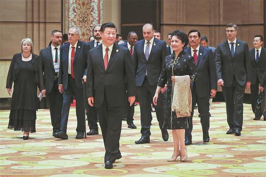 President Xi Jinping and his wife, Peng Liyuan, lead guests attending the China International Import Expo to a welcoming banquet in Shanghai on Sunday. (XU JINGXING / CHINA DAILY)