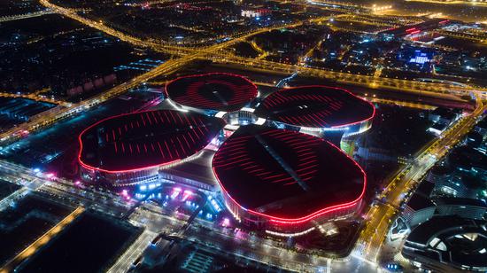 The National Exhibition and Convention Center in Shanghai lights up the night sky. The six-day China International Import Expo opened at the center on Monday. (Photo/Xinhua)