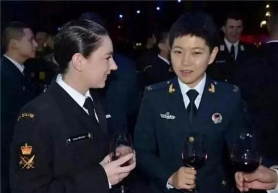 Song Xi, representing the Chinese Navy, communicates with a soldier from New Zealand. (Photo/Guangming Daily)