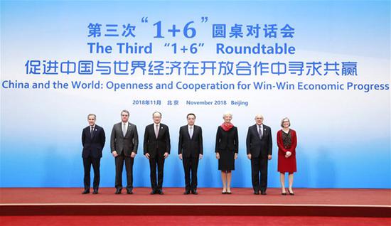 Chinese Premier Li Keqiang (C), together with World Bank Group President Jim Yong Kim (3rd L), IMF Managing Director Christine Lagarde (3rd R), WTO Director-General Roberto Azevedo (2nd L), OECD Secretary-General Angel Gurria (2nd R), Financial Stability Board (FSB) Chairman Mark Carney (1st L) and International Labor Organization (ILO) Deputy Director-General Deborah Greenfield (1st R), poses for a group photo before the third 