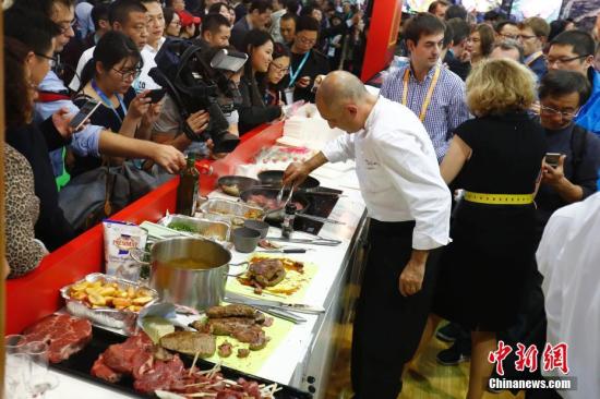 A chef cooks food for the audience at the first China International Import Expo in Shanghai, Nov. 6, 2018. (Photo/China News Service)