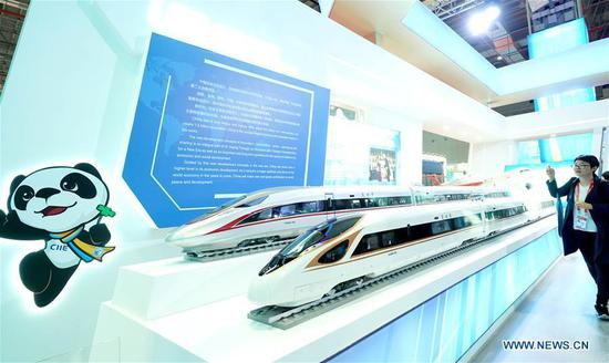 A journalist shoots models of China's Fuxing bullet train at the China Pavilion during the first China International Import Expo (CIIE) in Shanghai, east China, Nov. 5, 2018. (Xinhua/Chen Jianli)