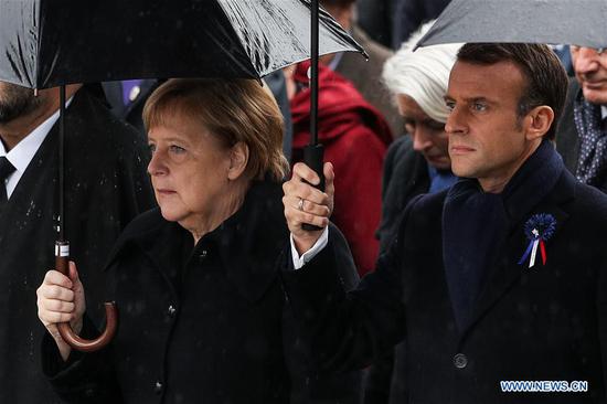 French President Emmanuel Macron and German Chancellor Angela Merkel walk to the ceremony to commemorate the 100th anniversary of the end of World War I in Paris, France, Nov. 11, 2018. (Xinhua/Zheng Huansong)