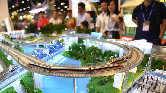  People watch a high-speed train model at the exhibition hall of the 15th China-ASEAN Expo in Nanning, south China's Guangxi Zhuang Autonomous Region, September 12, 2018. /Xinhua Photo)