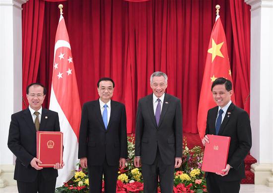 Chinese Premier Li Keqiang (2nd L) and Singaporean Prime Minister Lee Hsien Loong (2nd R) witness the signing of cooperation documents on upgrading the two countries' free trade agreement, connectivity, finance, science and technology, environment, culture and customs after their talks in Singapore, Nov. 12, 2018. (Xinhua/Shen Hong)