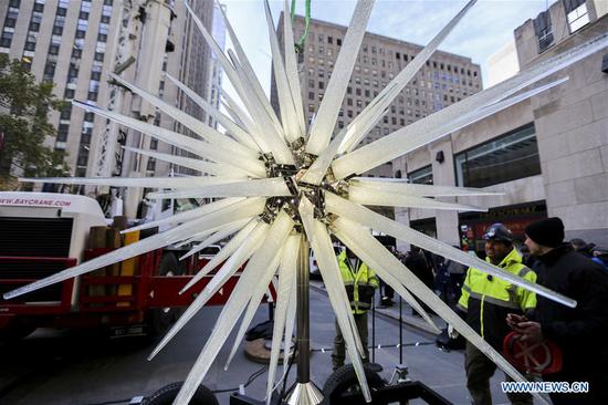 Workers prepare to hoist the Swarovski star to the top of the Rockefeller Center Christmas tree in New York, the United States, Nov. 14, 2018. A new star, which features 3 million Swarovski crystals on 70 illuminated spikes, was unveiled and raised to the top of the Rockefeller Center Christmas tree on Wednesday for the upcoming Christmas season. (Xinhua/Wang Ying)