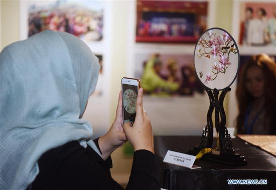 A visitor takes a photo of a Chinese embroidery work during the Splendid Chapters of Silk Road Cultures exhibition in Bandar Seri Begawan, Brunei, on Nov 15, 2018. A series of cultural exchange activities including exhibitions and seminars were held in Brunei's capital Bandar Seri Begawan on Thursday to boost China-Brunei cooperation. (Photo/Xinhua)