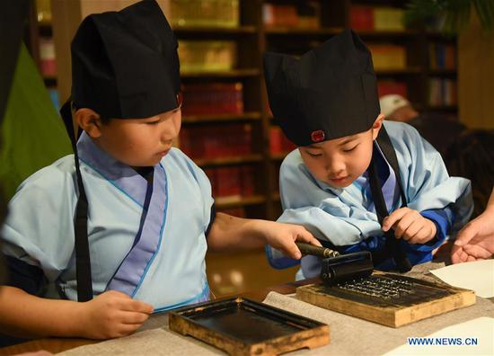 Students experience processes of movable-type printing in China's Liaoning 