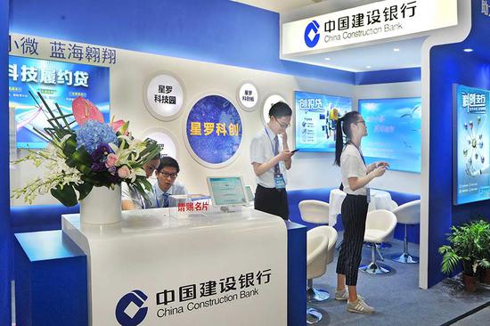 CCB employees work at the company's booth during a financial products exhibition in Shanghai. (Photo provided to China Daily)